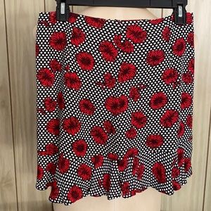 Mini skirt Red flowers on white dots zips on side ruffles along bottom.